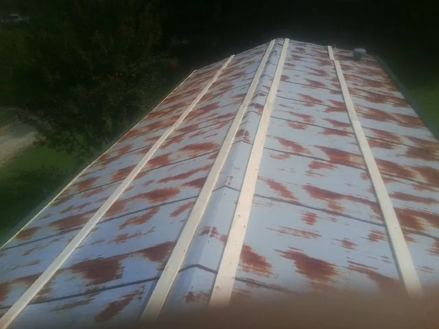 Rusted metal roof panels with new wood purlins before replacement — Storm Damage Roof Repair in Hacksneck by Roofing Brothers